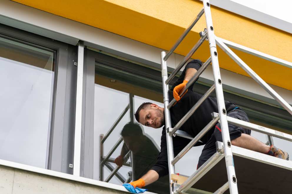Czyszczenie okna fix na piętrze przy użyciu drabiny zewnętrznej